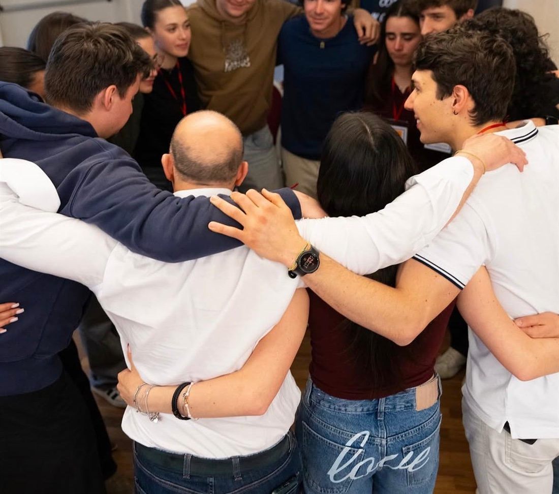 Partecipanti e formatore stretti in cerchio, abbracciati