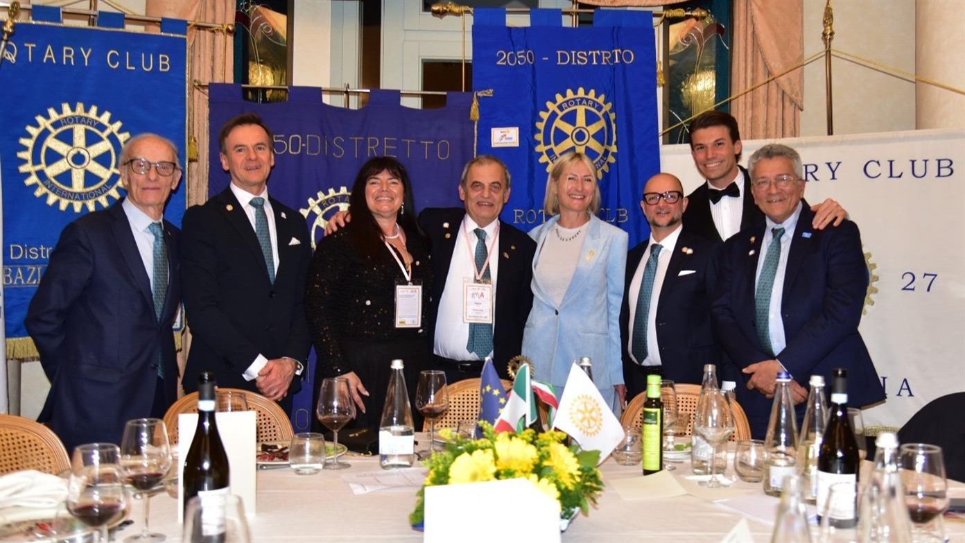 Soci e dirigenti Rotary riuniti davanti ai gonfaloni dei club