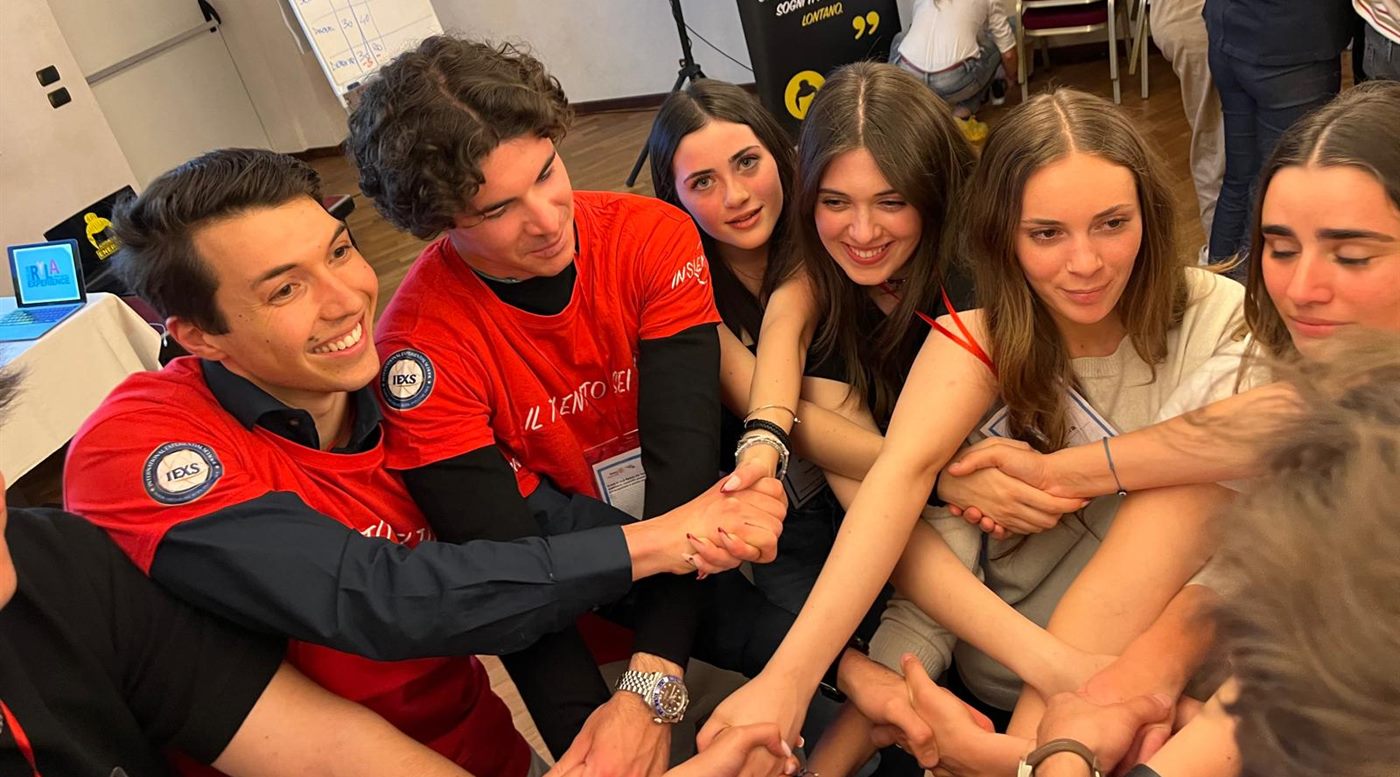 Un gruppo di partecipanti seduti insieme, con le mani intrecciate