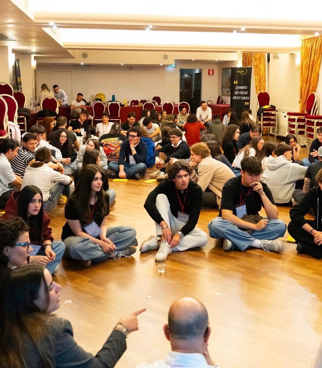 Partecipanti seduti a terra in cerchio durante una sessione di formazione